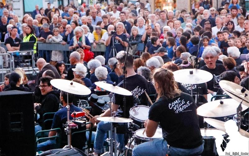 il gruppo Ologramma visto di spalle con in primo piano un batterista e il pubblico che si vede di fronte
