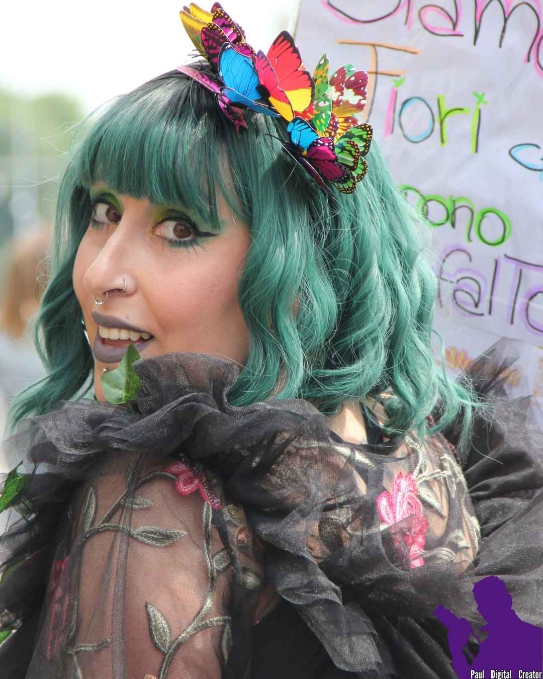 Una ragazza con cappelli verdi con un abito nero pieno di fiori