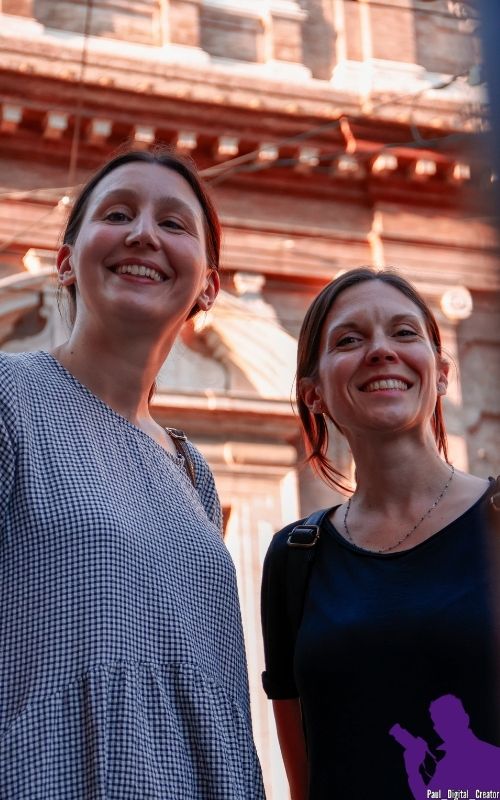 Due modelle che sorridono in centro a Modena con lo sfondo di una chiesa