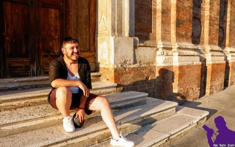 Modello seduto sulle scale della chiesa del Voto in via Emilia in centro storico a Modena